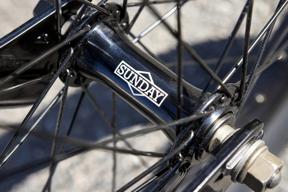Black Sunday BMX bike wheel hub with branded logo, black spokes, and durable metal construction.
