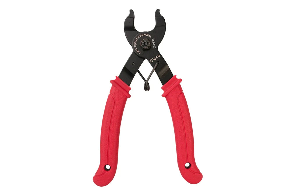 KMC Missing Link chain pliers with black metal jaws and ergonomic red rubber-coated handles.