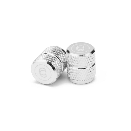 Silver knurled 6061 aluminum Schrader valve caps with Cinema logo detailing.