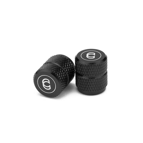 Black knurled 6061 aluminum Schrader valve caps featuring a white Cinema logo on the top.