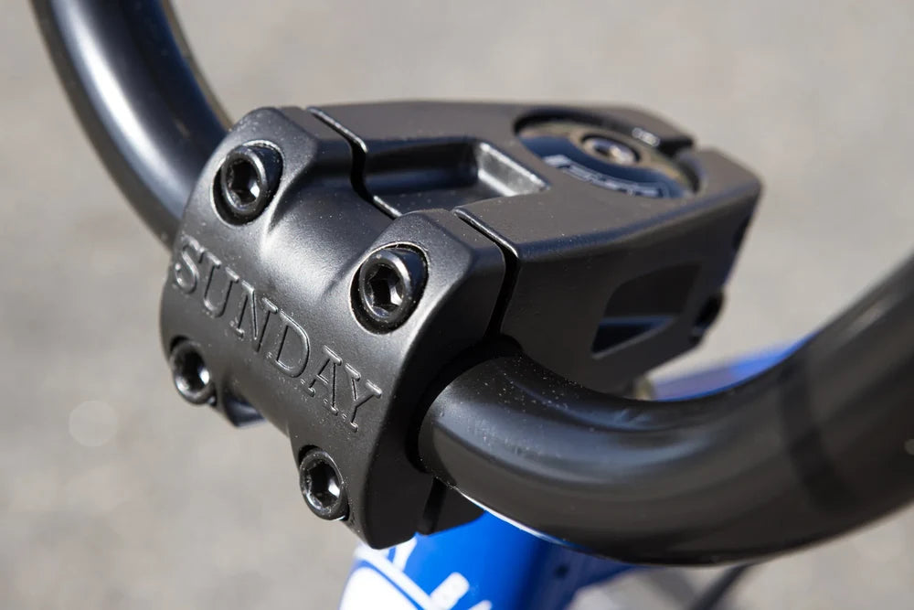 Black Sunday Freeze front load stem mounted on a glossy blue BMX bike frame with black handlebars.
