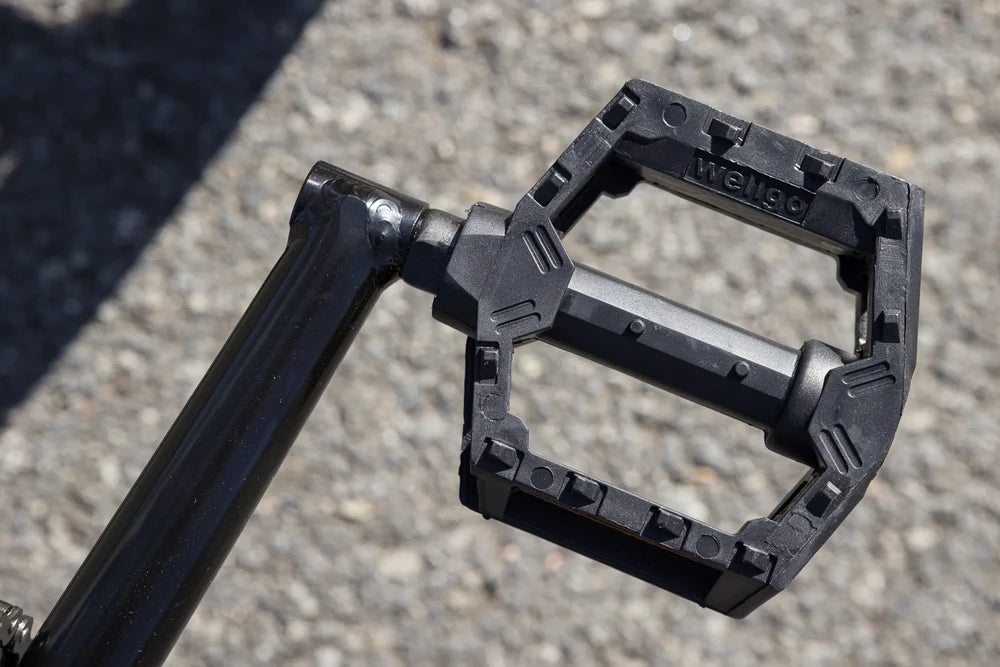 Black Wellgo BMX platform pedal attached to a glossy black crank arm on a Sunday Blueprint bike.